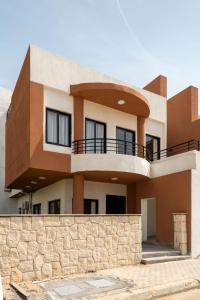 a modern house with a stone wall at Travelholic Residence Golden Gates in Cairo