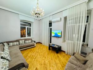 a living room with a couch and a chandelier at View of Baku Boulevard apartment by Bea Paradise in Baku
