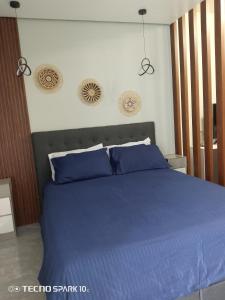 una camera da letto con un letto blu con cuscini blu di C&W Royal Oceancrest Mactan a Sudtungan