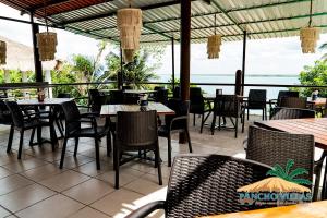 a restaurant with tables and chairs and a view of the ocean at Hotel Pancho Villas Bacalar - Gratis Renta Kayyaks in Bacalar