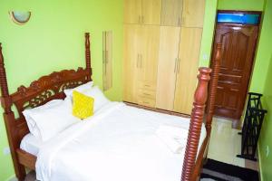 um quarto com uma cama grande e uma cabeceira em madeira em Exquisite 1bedroom located in Garden Estate, Thome em Nairobi