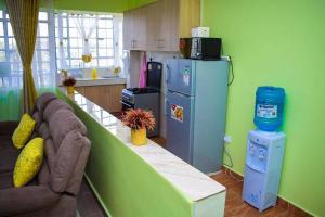 uma cozinha com um sofá e um frigorífico em Exquisite 1bedroom located in Garden Estate, Thome em Nairobi