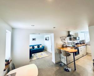 a kitchen and living room with a blue couch at The West Wing in Devizes