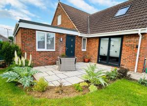a brick house with a patio with a chair at The West Wing in Devizes