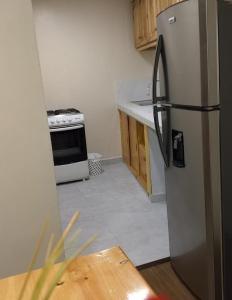 a kitchen with a stainless steel refrigerator and a stove at Hotel Cuencano Hogar in Cuenca