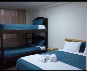 a room with two bunk beds with towels on them at Hotel Cuencano Hogar in Cuenca