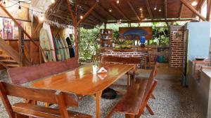 a dining room with a wooden table and chairs at Vistamar Guest House in Ayampe