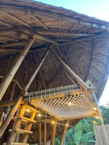 un gran techo de bambú con un banco debajo en Bamboo House - Ecobreeze, en Sidemen
