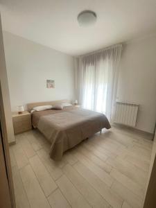 a bedroom with a bed and a large window at Palazzina del sole in Sottomarina
