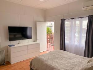a bedroom with a bed and a flat screen tv at West End Studio 5 in Brisbane