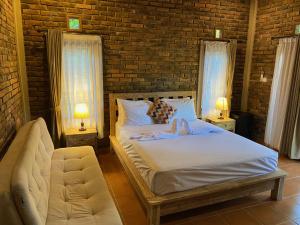 una camera da letto con un letto, una sedia e due finestre di Mayong Bali Villa and Hostel a Munduk