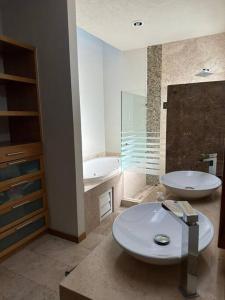 a bathroom with a toilet and a sink and a tub at Residencial Quinta las Acacias, Santa Fe, Juriquilla in Juriquilla