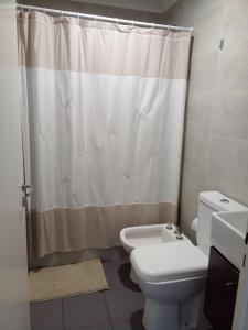 y baño con aseo y cortina de ducha. en Departamento santa fe en Santa Rosa