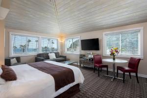 a hotel room with a bed and a table and chairs at Glenmore Plaza Hotel in Avalon +13 photos
