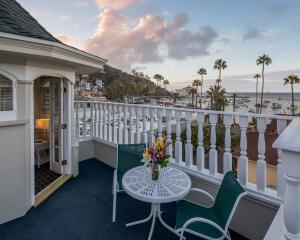 a balcony with a table and chairs and a view of the ocean at Glenmore Plaza Hotel in Avalon