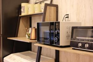 two microwaves are sitting on a shelf at Saifu House - Vacation STAY 29910v in Dazaifu