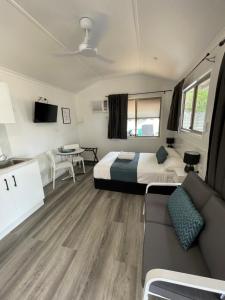 a room with a bed and a couch and a table at Ellis Beach Oceanfront Holiday Park in Palm Cove