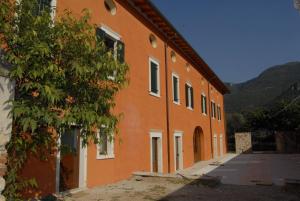 an orange building with a tree next to it at Agriturismo Al Palazzo in Rivalta di Brentino +14 photos