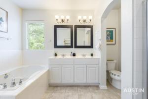 a white bathroom with a tub and a toilet at Perfect Central Location w Free Prkg and Cozy Beds in Austin +32 photos