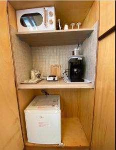 a small kitchen with a refrigerator and a microwave at Caieta: la casa nella roccia in Gaeta +20 photos