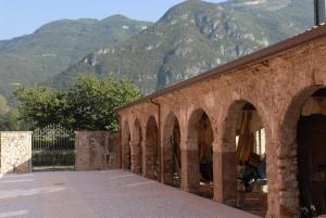 a stone bridge with a mountain in the background at Agriturismo Al Palazzo in Rivalta di Brentino