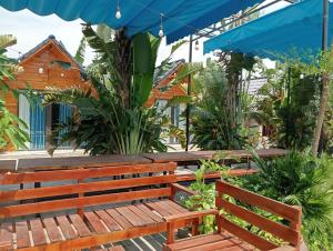 un banc en bois assis sous un parapluie bleu dans l'établissement Tamcoc Metoo Bungalow 2, à Ninh Binh