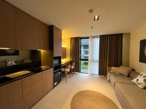 a kitchen and living room with a couch and a table at Cozy Minimalist Apartment Lavaya N511 in Nusa Dua