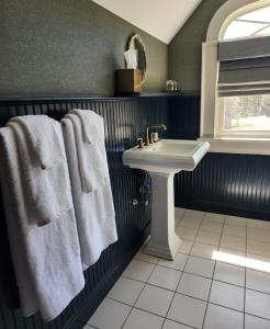 uma casa de banho com toalhas brancas e um lavatório em The Wainscott Inn em Sagaponack