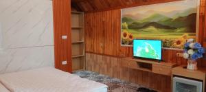 - une chambre dotée d'une télévision sur un mur en bois dans l'établissement Tamcoc Metoo Bungalow 2, à Ninh Binh