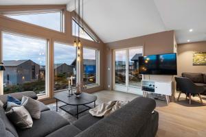 a living room with a couch and a flat screen tv at Luxurious cottage outside Bergen with Jacuzzi in Forland