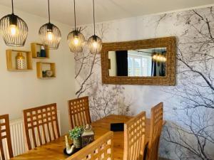 jadalnia ze stołem i lustrem w obiekcie Picture perfect Holiday Home in Sourbrodt with Garden BBQ w mieście Sourbrodt