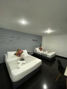 een kamer met twee bedden en een bord aan de muur bij Hotel Aura Medellin in Medellín