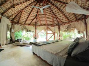 Dream Glamping Jungle Bohio tesisinde bir odada yatak veya yataklar