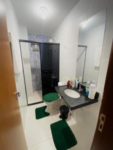 ein Badezimmer mit einem Waschbecken, einem WC und einem Spiegel in der Unterkunft Apartamento para São João in Campina Grande