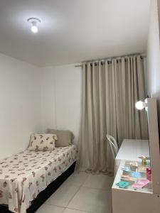 Habitación pequeña con cama y escritorio. en Apartamento para São João en Campina Grande