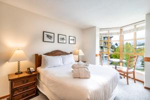 a bedroom with a large bed and a window at Cascade by Elevate Vacations in Whistler