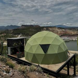 a green building with a view of a mountain at HOOGA glamping - Presa de Zimapán in Tecozautla