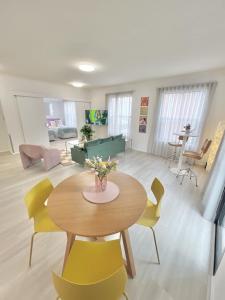 a living room with a table and yellow chairs at 2BDR 1BTH 1PRK - James Jem in Perth