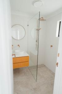 uma casa de banho com um chuveiro e um lavatório. em Austinvilla Estate em Mudgeeraba