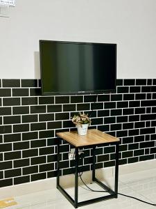 a flat screen tv on a wall with a table at Selesa Hill Homestay M in Tok Tok
