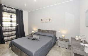 a bedroom with a large bed and a bathroom at Stunning Home In Avola in Avola