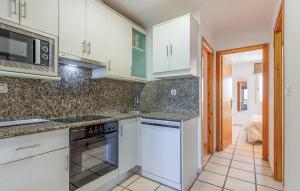 a kitchen with white cabinets and a stove top oven at Cozy Home In San Pedro Del Pinatar in San Pedro del Pinatar