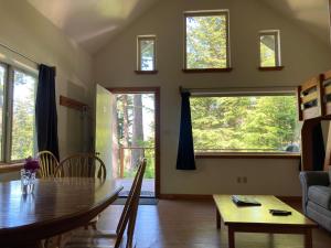 a living room with a table and chairs and windows at Beach Roadhouse in Haines
