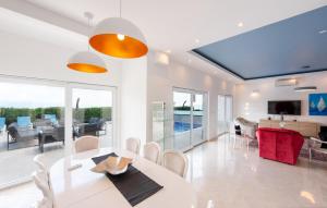 a dining room with a white table and chairs at 5 Bedroom Lovely Home In Poljane in Poljane