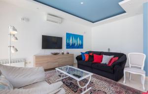 a living room with a black couch and a tv at 5 Bedroom Lovely Home In Poljane in Poljane