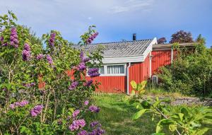uma casa vermelha com um jardim com flores roxas em 3 Bedroom Nice Home In Bog By em Bogø By