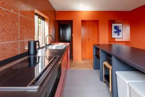 a kitchen with a sink and an orange wall at Villa Secca in Futo