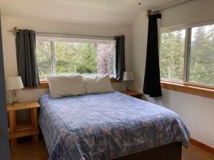 ein Schlafzimmer mit einem Bett und einem großen Fenster in der Unterkunft Beach Roadhouse in Haines