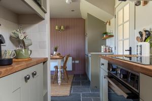 a kitchen with white cabinets and a counter top at The Stable Bothy in Rogart +22 photos