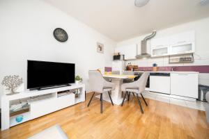 a kitchen with white cabinets and a table and chairs at Holiday house with a parking space Dugi Rat, Omis - 23046 in Dugi Rat +10 photos